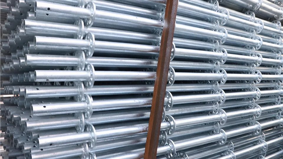 Hot-dip galvanized Ringlock scaffolding standards stacked in steel stillages at the factory